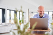 © Jo Kirchherr/Westend61 - Entrepreneur smiling while working on laptop at home