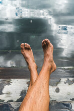 Bare Feet Of Man Relaxing On Steps Of Underground Cenote