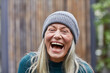 © Maya Claussen/Westend61 - Laughing mature woman against house