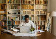 © VALENTINA BARRETO STUDIO/Westend61 - Male environmentalist using laptop while working on wind turbine project at home office