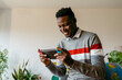 © VALENTINA BARRETO STUDIO/Westend61 - Smiling businessman playing on handheld video game at home during break from work