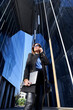 © victor espadas gonzalez/Westend61 - Female entrepreneur talking on smart phone amidst downtown district on sunny day