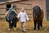 Girl and pony. Child and horses on the farm in the paddock. Equestrian school. Hippotherapy at the hipodrome.