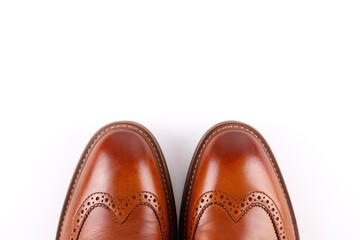 Poster - Cropped shot of a pair of light brown double monk strap shoes isolated on white background. Versatile business casual dress shoes without laces. Top view, copy space for text, flat lay.