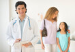 © Tetra Images/Tetra Images - Doctor with patients (woman and girl aged 12-13) in office