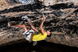 © GER/Westend61 - Young male athlete climbing rock with effort in cave