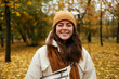 © alev/Westend61 - Happy young woman in warm clothing in autumn park