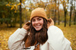 © alev/Westend61 - Happy young woman with hand in hair in autumn park