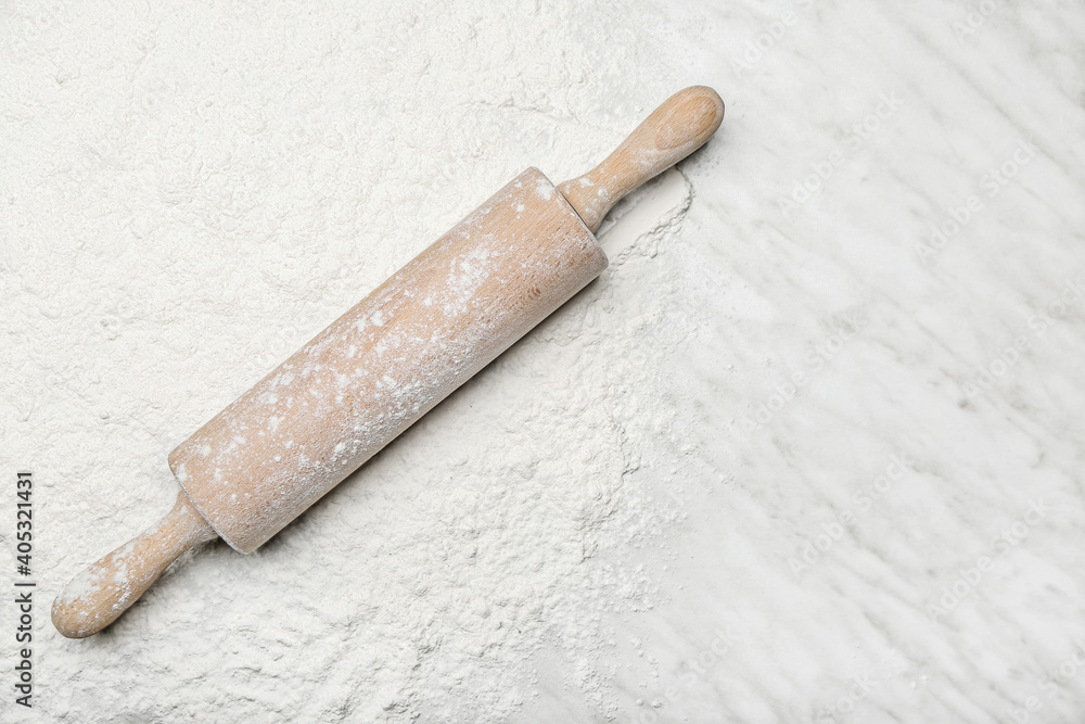 Wooden rolling pin on wheat flour background