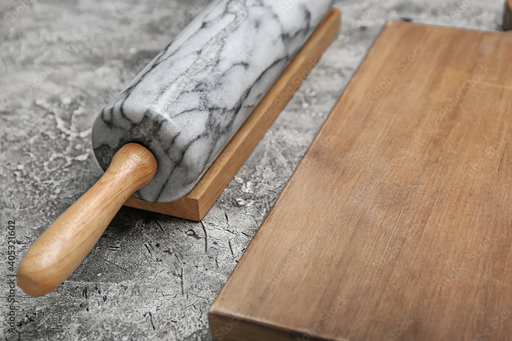 Marble rolling pin and board on grunge background