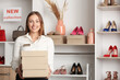 © Pixel-Shot - Female seller in modern shoe store