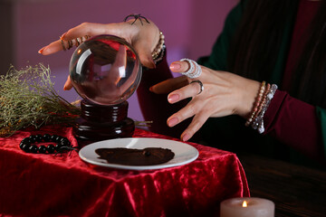 Fortune teller reading future at table