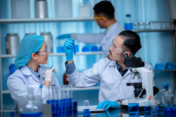 Wall Mural - group of laboratory assistants checking blood, using microscope and doing test for bacteria