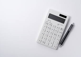 a calculator and pen on a white background