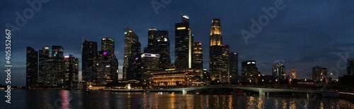 Fototapeta Illuminated Modern Buildings By River Against Sky At Night