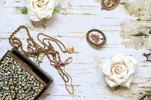 Jewelry Box With Vintage Pin, Necklace And White Flowers.  Top View On Old White Wood. Women’s Day Concept