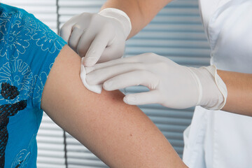 Wall Mural - woman doctor making a vaccination injection with a syringe at hospital