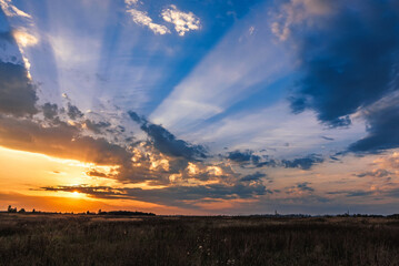 beautiful colorful sunset with orange rays of the sun in the blue sky in the evening in autumn