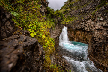 waterfall among green rocks