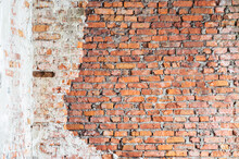 An Old Red Brick Wall With Remnants Of White Plaster. Vintage Background