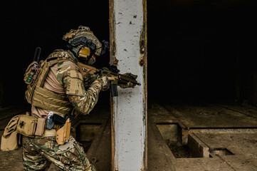 Special forces soldier doing tactical training in building clearing (CQB). He is wearing multicam uniform and assault rifle HK416.