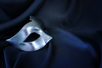 Photo of elegant and delicate Venetian mask over black silk background