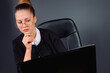 © Viorel - Enlarged photo of a business woman with glasses looking seriously to the laptop. Grey background.