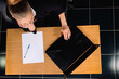 © Viorel - Photo from above. Businesswoman sits at a computer in the office with documents on the table.