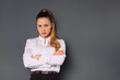 © Viorel - Portrait of a serious business woman in a white shirt on a gray background with empty side space.