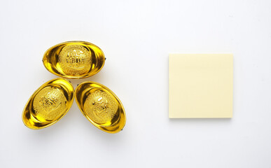 A picture of notepad and golden ingot or 