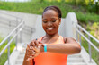 © Syda Productions - technology, sport and people concept - happy smiling young african american woman with fitness tracker outdoors