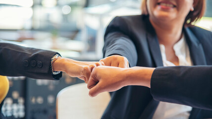 Wall Mural - Group of diversity people fist bump holding hands together power of tag team. Teamwork Multiethnic people group working togetherness. Business people team holding hands successful. Business meeting