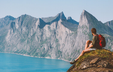 Wall Mural - Man traveler sitting on cliff mountain travel vacations in Norway backpacker enjoying landscape adventure lifestyle outdoor activity Senja islands