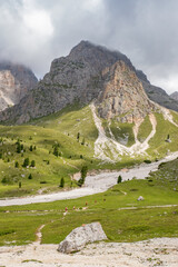 Wall Mural - mountainous landscape view and a group with hikers on a trail