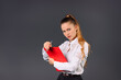 © Viorel - Serious young businesswoman with a red folder on a gray background posing. Side white space.