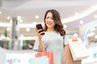 © Timeimage - Young girl is shopping and using the phone at the mall