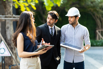 Wall Mural - Young Executive CEO business man and woman secretary meeting with energy engineer plan a project to build a solar panel for the building under construction.