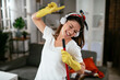 Young attractive woman cleaning home. Happy beautiful woman listetning the music, enjoying in cleaning