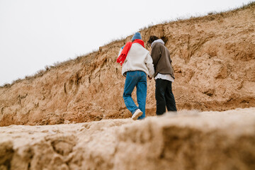 Wall Mural - Attractive young multiethnic couple walking at the beachside