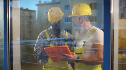 Wall Mural - Team of builders with tablet computer working indoors