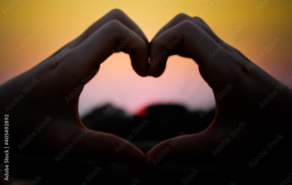 Cropped Hands Of Woman Making Heart Shape Against Clear Sky During Sunset - obrazy, fototapety, plakaty 
