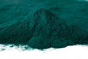 Heap of spirulina algae powder on a white background. Super food concept. Macro photography.