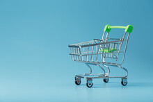 Empty Shopping Cart For Goods From The Supermarket On A Blue Background.