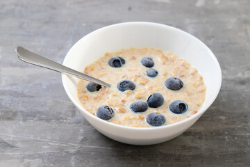 Sticker - healthy wheat flakes with milk and blueberries in white bowl