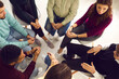 © Studio Romantic - Concept of group therapy meeting, talking about and dealing with psychological problems, getting help and support. High angle of diverse people sitting in circle listening to man sharing his concerns