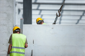 Canvas Print - Selective focus shot of workers in the construction of a residential complex