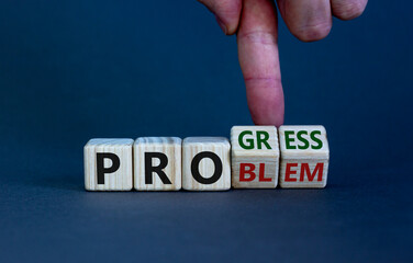 Problem or progress symbol. Businessman hand turns wooden cubes and changes the word 'problem' to 'progress'. Beautiful grey background. Business and problem or progress concept. Copy space.