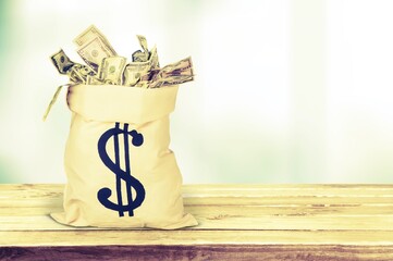 Wall Mural - Money bag with dollars money on a desk