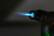 Blue flame with a manual gas burner with a black background. Close-up.