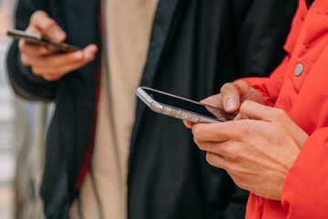 hands with mobile phones of young people on the street